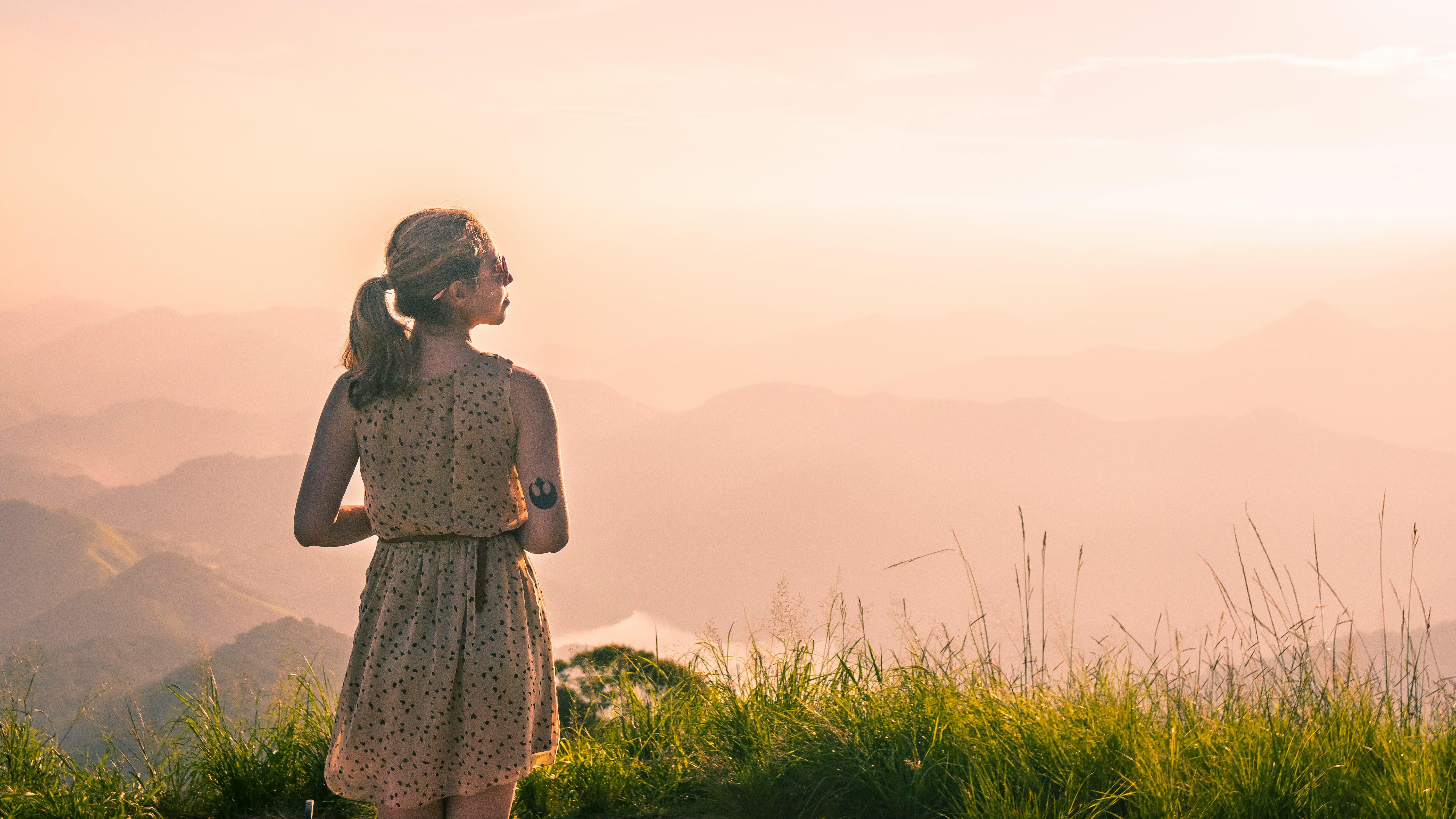 woman standing on green grass looking side